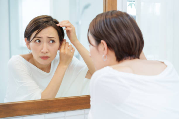 istock attractive asian woman checking her hair in a makeroom 1469859826