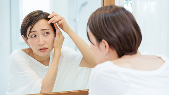 attractive asian woman checking her hair in a makeroom