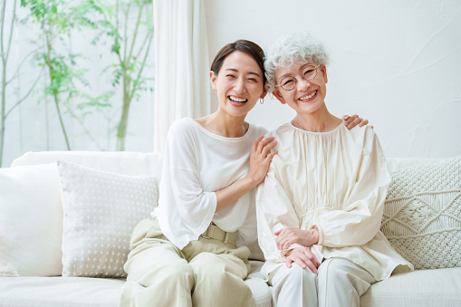 asian mother and daughter relaxing in a living room