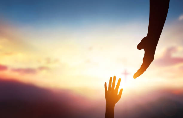 istock religious concept,God's helping hand and cross on sunset background 1469866072