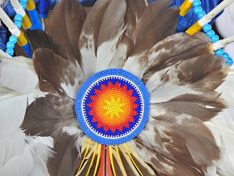 An Indian headdress with eagle featheres and on a white background.