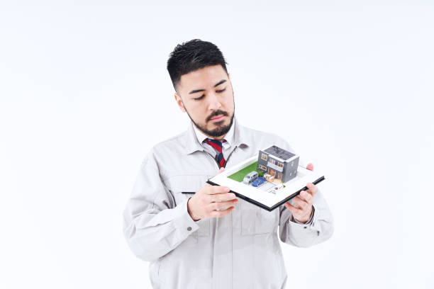 un hombre en ropa de trabajo con una modelo de casa - figurine small businessman discussion fotografías e imágenes de stock