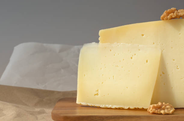istock Two slices of hard cheese with walnuts on a gray background 1469870396