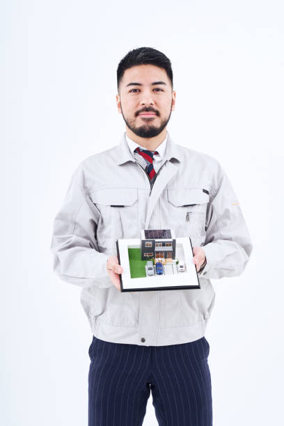 un hombre en ropa de trabajo con una modelo de casa - figurine small businessman discussion fotografías e imágenes de stock
