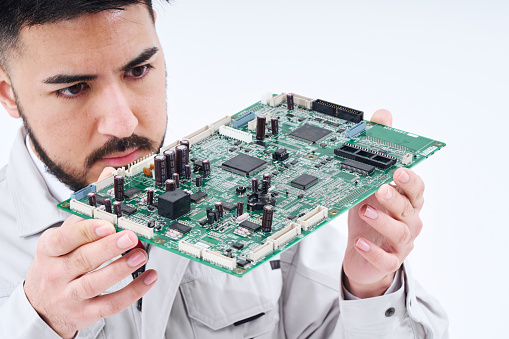 A man in work clothes with a computer board  and white background