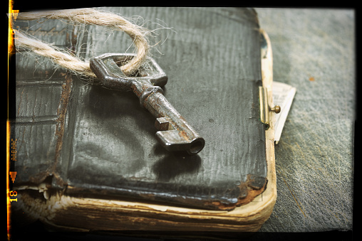 Old key on a old book, antique wood background. Real estate concept