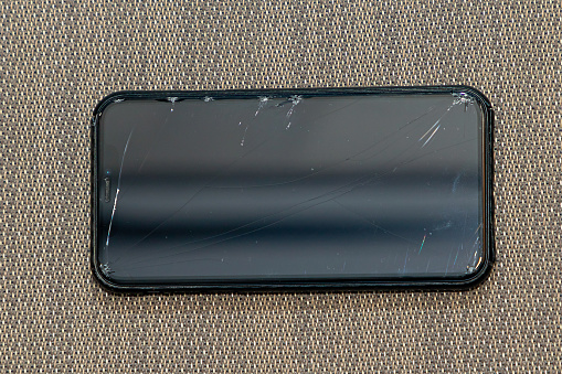 Broken mobile phone glass display with visible cracks