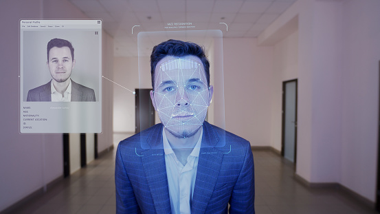 Businessman scans face in office. He touches sensor and security system identifies. 3D hologram of human biometric facial recognition and personal virtual profile. Identification and AI technology.