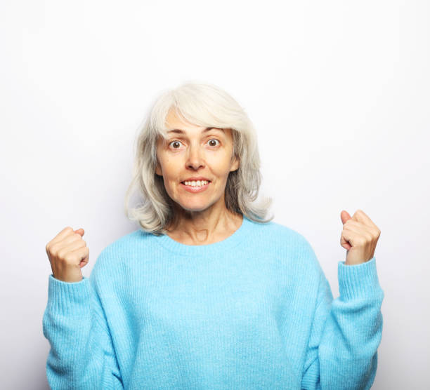 istock Happy elderly female wearing blue sweater smiling over white background 1469881618