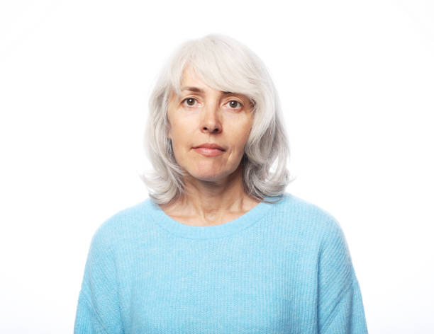 istock Happy elderly female wearing blue sweater smiling over white background 1469881619