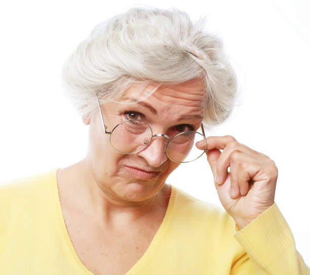 istock An elderly woman looks skeptically over her glasses. 1469882340