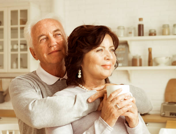 istock Happy elderly couple drinking coffee in the kitchen while sitting at the table. 1469882361