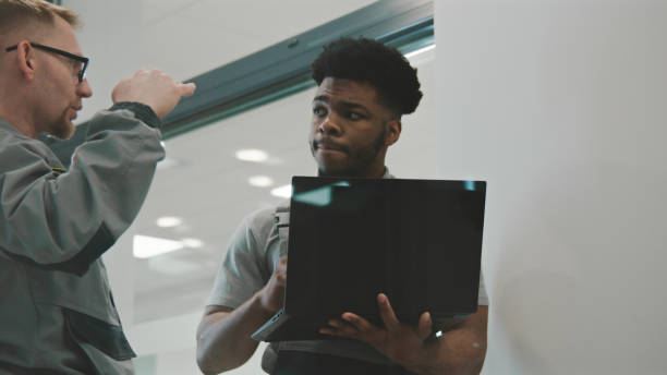 istock Installers set up security cameras on laptop 1469884583