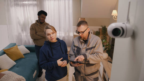 istock Installer sets up security cam for family 1469887828