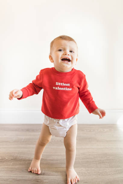 A Cute 14monthold Baby Boy Whining Complaining Standing Barefoot With Arms  Out And Wearing A Red Sweater That Says Littlest Valentine With A  Nudecolored Cloth Diaper While On A Wooden Hardwood Floor