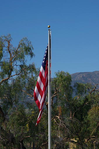 US flag with blue sky above on a calm day