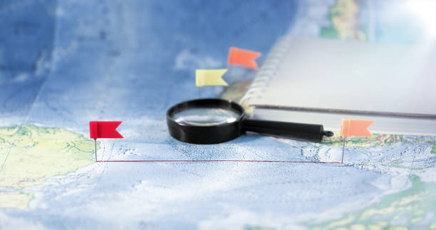 istock Red location pointer, a Magnifying glass and a notepad on the world map. Concept of navigation and venue. Tourism and travel. 1469893356