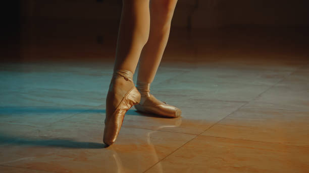 istock Close up graceful ballet dancer feet in pointe shoes 1469894295