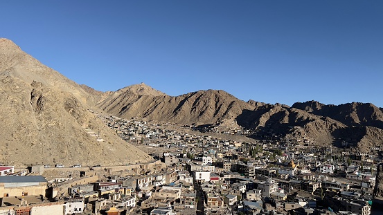 Leh town seen from above with many houses and mountains surrounded at Ladakh, in the Indian Himalayas.