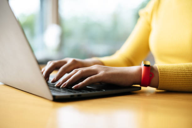 istock Young woman wearing smartwatch using laptop computer 1469895897