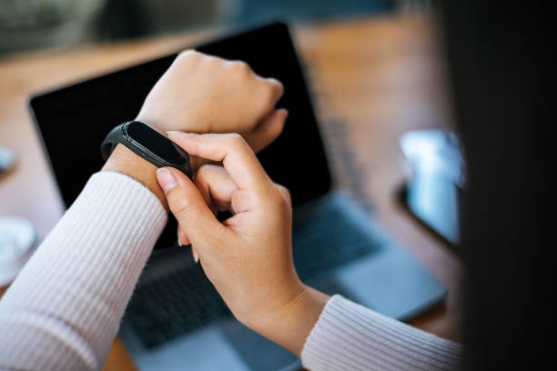 istock Young woman using smartwatch and workon laptop computer in cafe 1469896028
