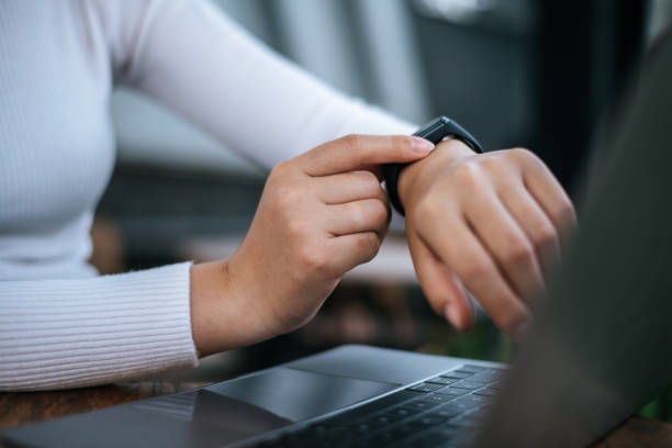 istock Young woman using smartwatch and workon laptop computer in cafe 1469896669