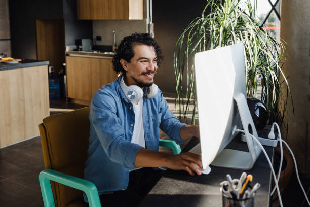 istock Young Hispanic Man Working from Home on Desktop Computer in Sunny Stylish Loft Apartment. Creative Designer home office in Mexico Latin America 1469896779