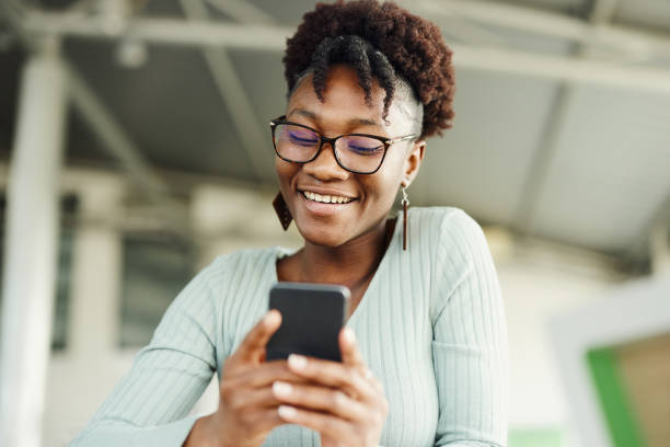 istock Happy black woman text messaging on mobile phone. 1469898911
