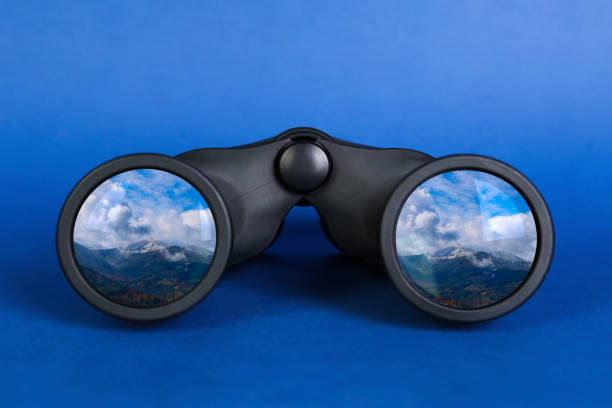 istock Binoculars on blue background. Mountain landscape reflecting in lenses 1469900509