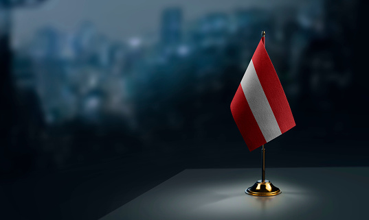 Small flags of the Austria on an abstract blurry background.