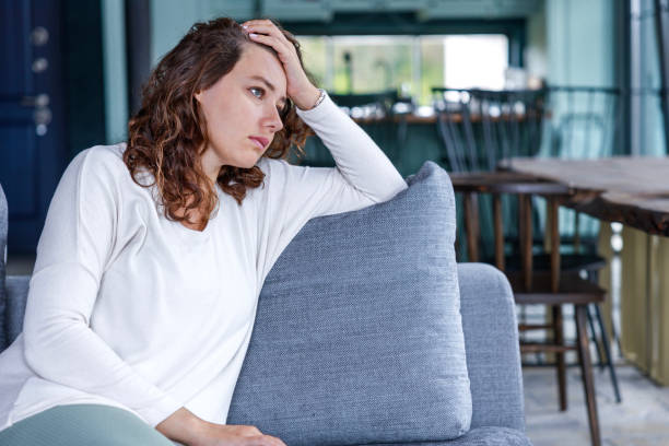 istock Stressed young woman sitting on sofa 1469902695