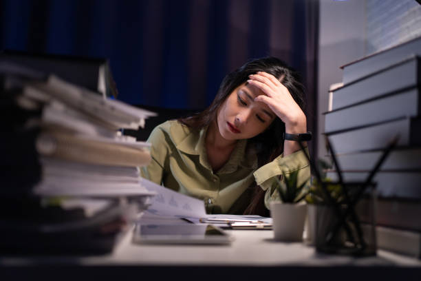 istock Woman working overtime on a desk at night 1469903006
