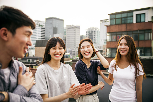 Group of asians friends celebrate a birthday on a rooftop in downtown.