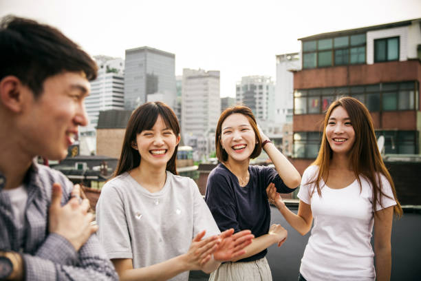 Group of asians friends celebrate a birthday on a rooftop in downtown stock photo