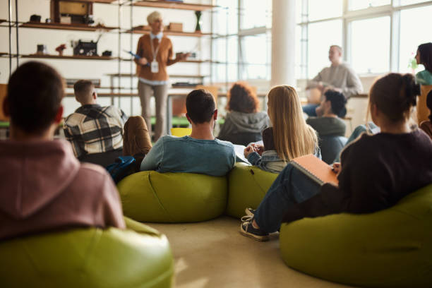istock Rear view of students having a class at casual classroom. 1469904533