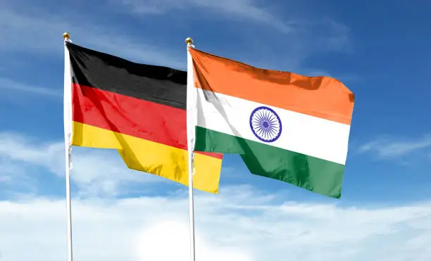 Photo of German flag with Indian flag on cloudy sky. waving in the sky