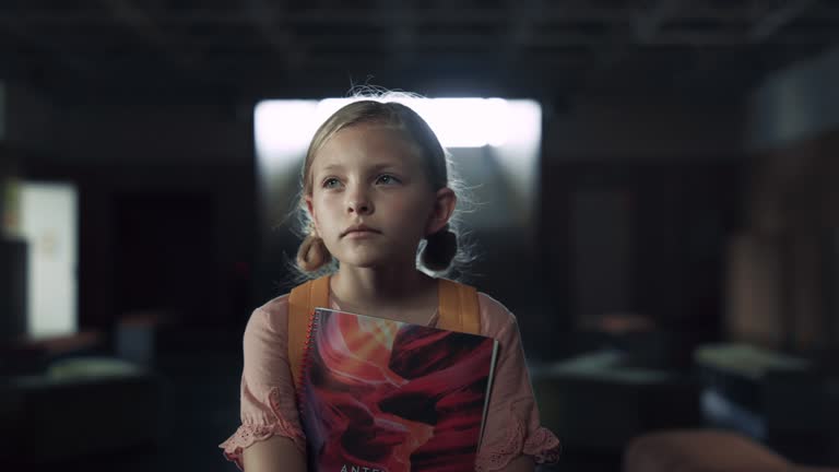 Schoolgirl holding books afraid to enter classroom closeup. Teen child standing.