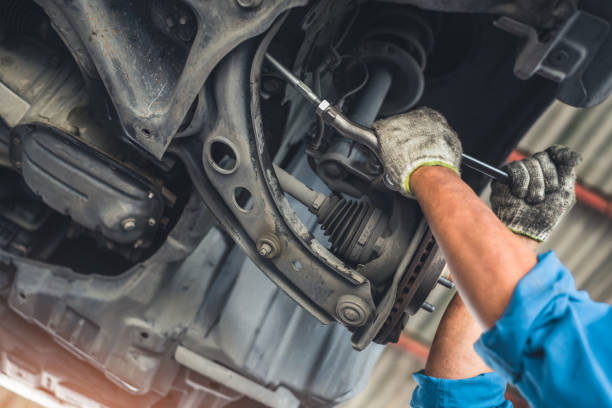 istock man changes a wheel hub with a wheel bearing in a car, Car disk brake pad replacement service by hand of mechanic man in car garage 1469910431