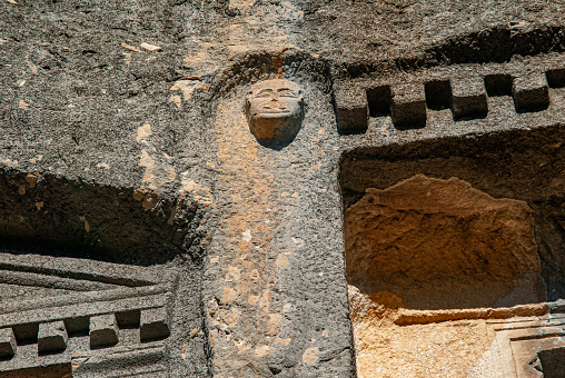 A round engraved stone with Aztec calendar on a wooden background