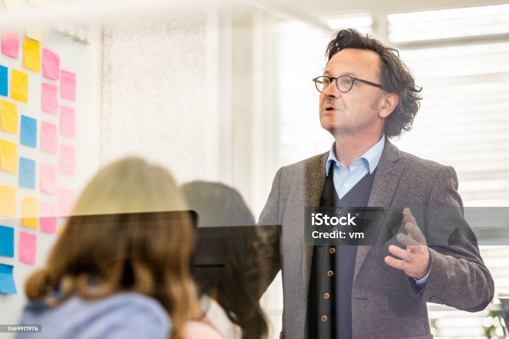 Business coach training corporate workers in conference room Business coach training corporate workers in conference room, medium shot. Mid adult male project manager speaking in office meeting, front side view Agile Methodology Stock Photo