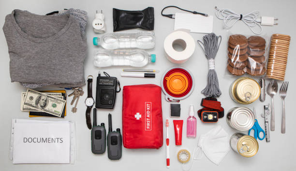 istock Emergency backpack equipment organized on the table. Documents, water,food, first aid kit and another items needed to survive. 1469912368