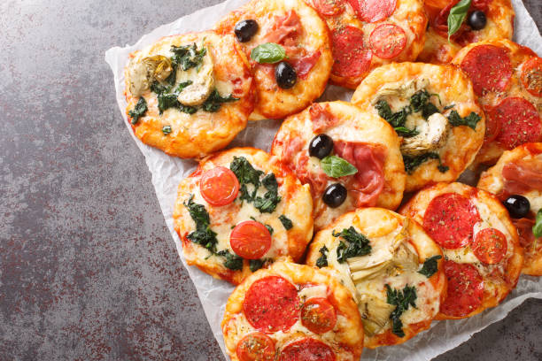 istock Italian Pizzette Mini Pizza Bites With Assorted Toppings close-up on parchment. Horizontal top view 1469912487