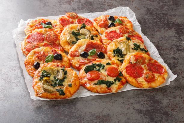 istock Hot assorted mini pizza or Pizzette with various toppings close-up on parchment. horizontal 1469912520