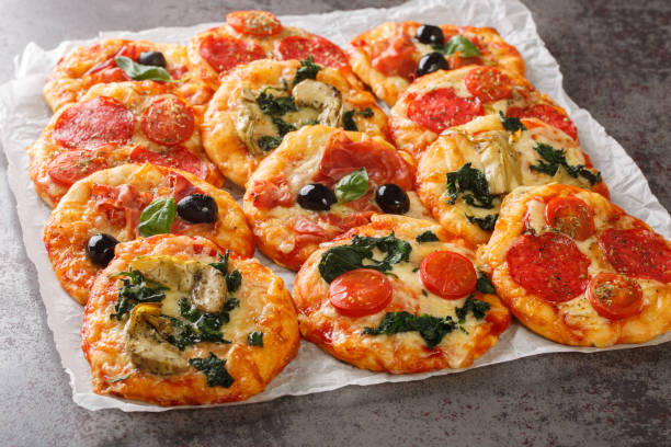 istock Italian Pizzette Mini Pizza Bites With Assorted Toppings close-up on parchment. Horizontal 1469912575