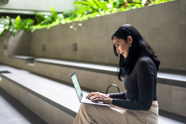 Indian businesswoman working on computer in public area
