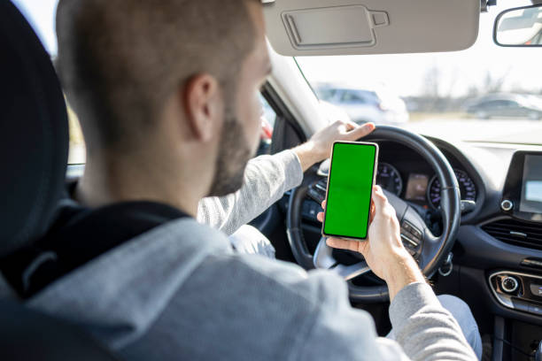 istock Driver hand holding blank green screen smartphone 1469915823
