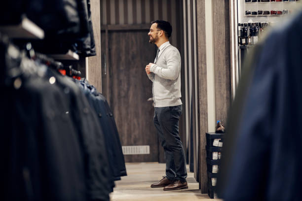 istock A happy young elegant man is trying out clothes at the store. 1469917465