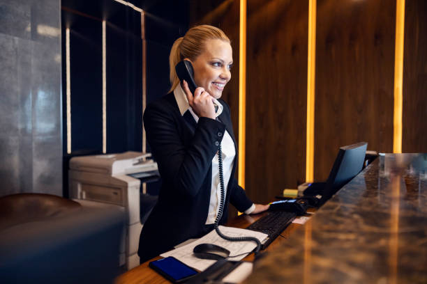 istock A happy receptionist is answering guest's call from a hotel in reception. 1469919189