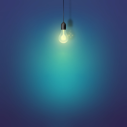 Glowing light bulb with the light spot on the wall. Template for text. Loft interior concept design.