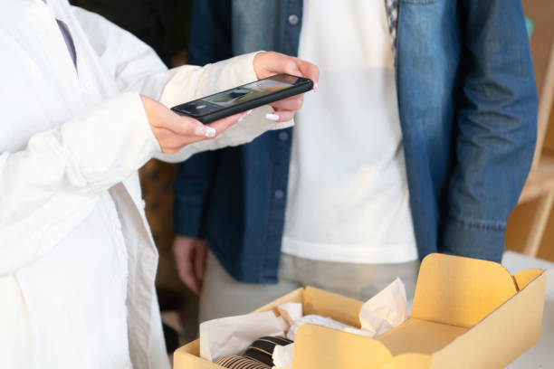 istock Young couple runs a small business making clay jewelry. Help each other check and record images before packaging in the box to send to customers. 1469922287